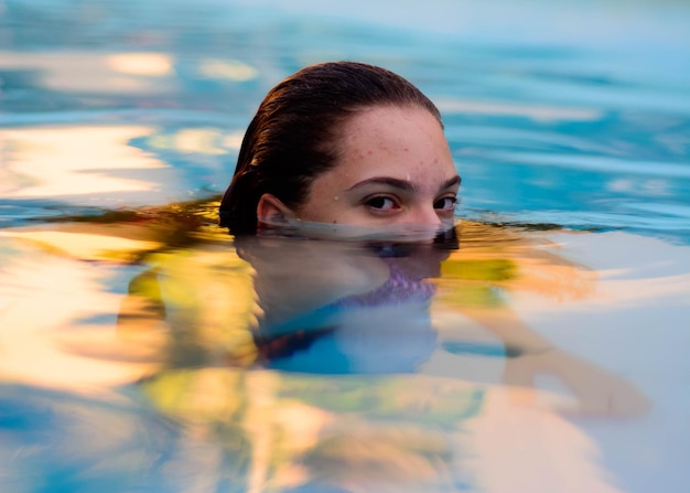 Foto retrato de uma menina nadando na piscina