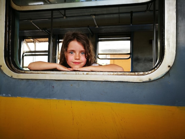 Retrato de uma menina olhando através da janela de um trem