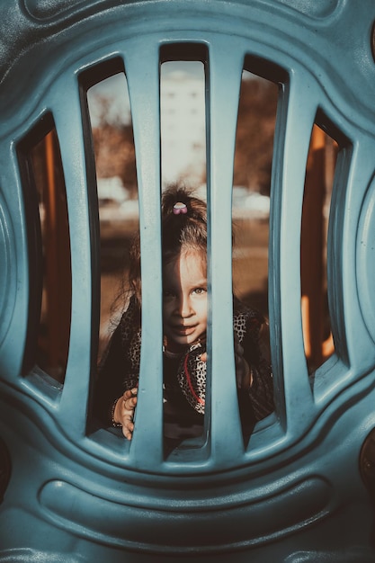 Foto retrato de uma menina olhando através de uma cerca