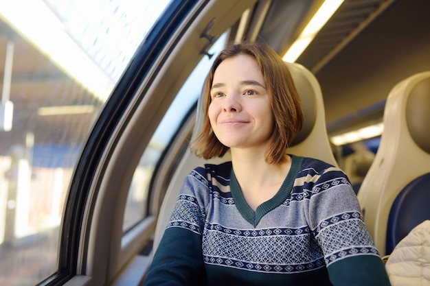 Retrato de uma menina pensativa bonita que sonha em um carro de trem.