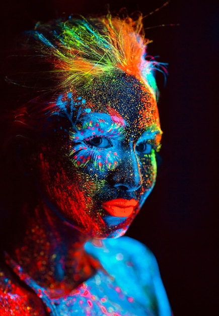 Retrato de uma menina pintada em pó fluorescente.