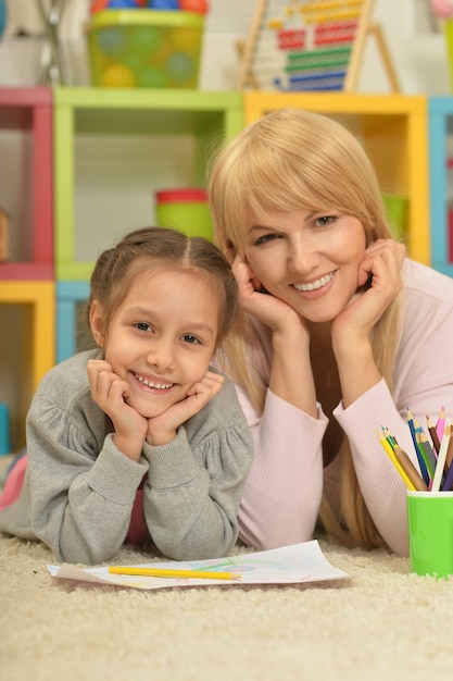 Foto retrato de uma menina pintando com a mãe