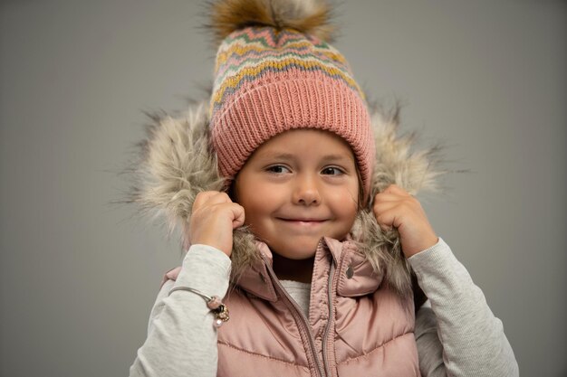 Retrato de uma menina posando de casaco quente e chapéu isolado sobre fundo branco Copiar espaço para anúncio