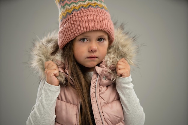 Retrato de uma menina posando de casaco quente e chapéu isolado sobre fundo branco Copiar espaço para anúncio