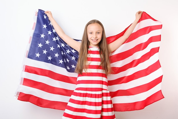 Retrato de uma menina positiva com uma bandeira americana nas mãos