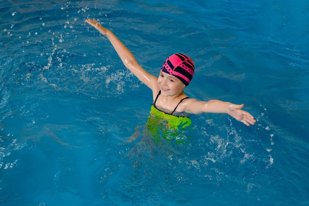 Retrato de uma menina se divertindo na piscina coberta