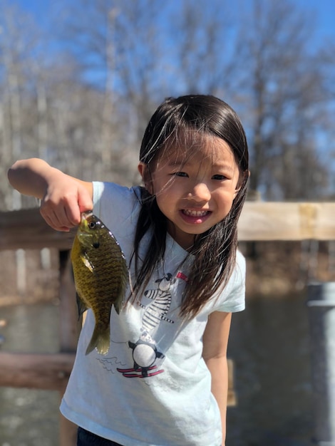 Retrato de uma menina segurando um peixe