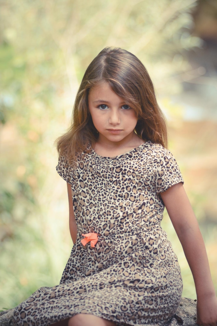 Foto retrato de uma menina sentada em uma rocha