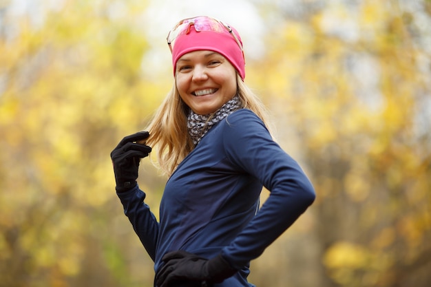 Retrato de uma menina sorridente com roupas esportivas na floresta