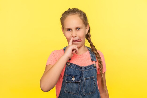 Foto retrato de uma menina sorridente contra um fundo amarelo