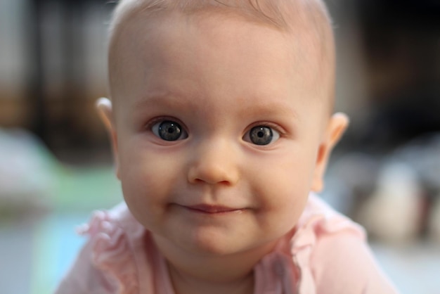 Retrato de uma menina sorridente de 8 meses tocando e fofo retrato de iluminação solar de foto interna na frente