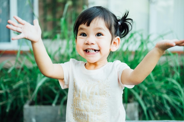 Retrato de uma menina sorridente de pé contra as plantas