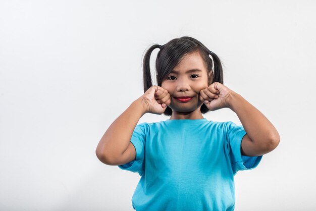 Retrato de uma menina sorridente de pé contra um fundo branco