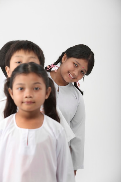 Foto retrato de uma menina sorridente de pé contra um fundo branco