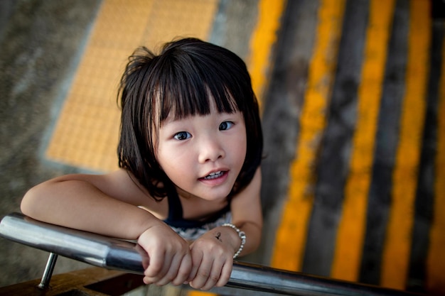 Retrato de uma menina sorridente de pé junto ao corrimão