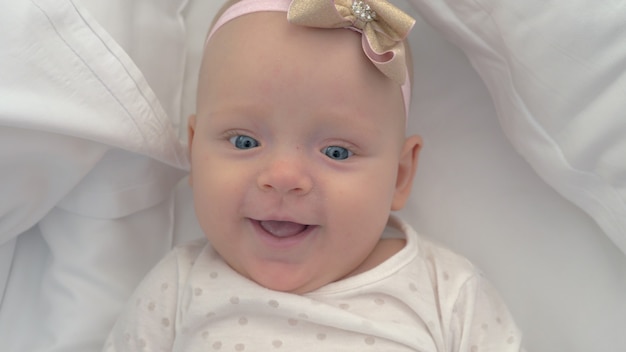 Retrato de uma menina sorridente de seis meses de olhos azuis