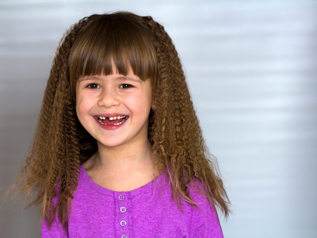 Retrato de uma menina sorridente feliz com belos cabelos grossos