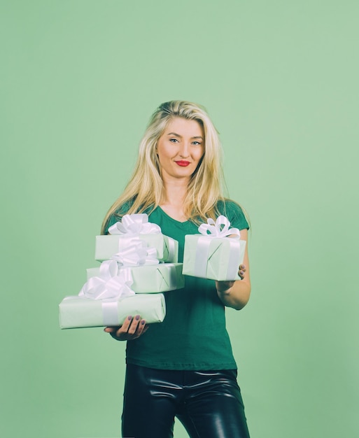 Retrato de uma menina sorridente feliz em verde segurando a caixa de presente