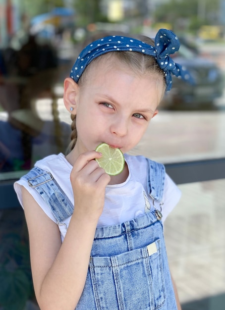 Retrato de uma menina sorridente segurando fatias de limão