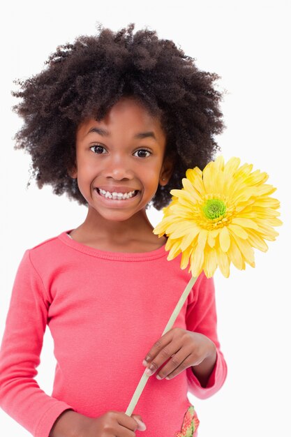 Retrato de uma menina sorridente segurando uma flor