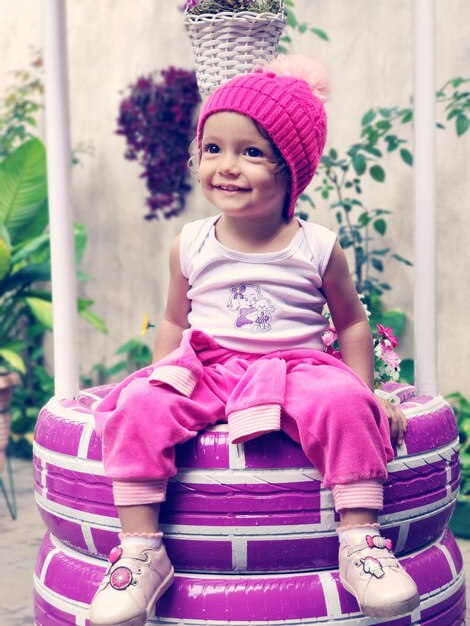 Foto retrato de uma menina sorridente sentada ao ar livre