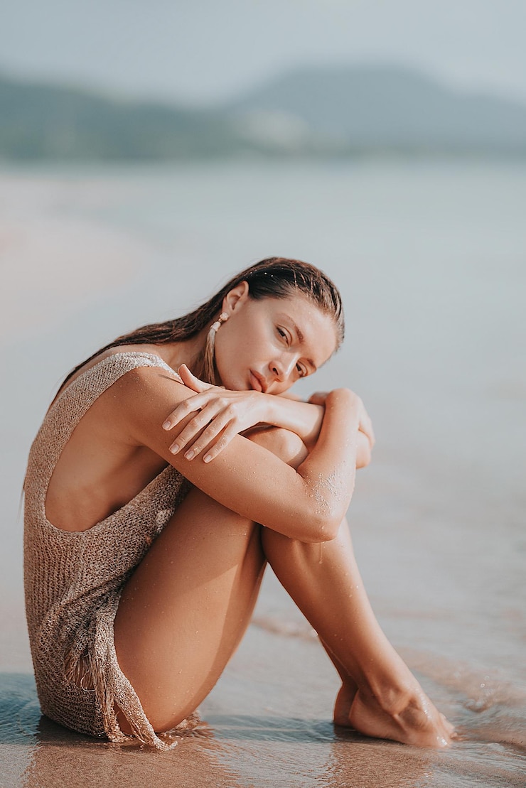Foto retrato de uma menina sorridente sentada na praia