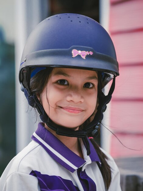 Retrato de uma menina sorridente usando capacete ao ar livre