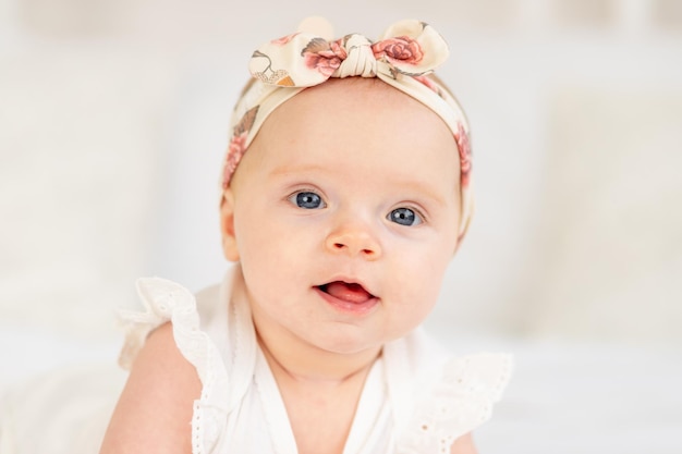 Retrato de uma menina sorrindo ou rindo deitada em uma cama de algodão branco em casa