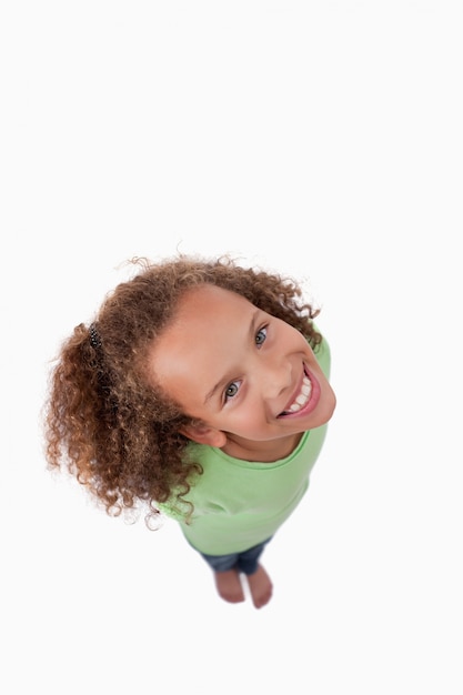 Retrato de uma menina sorrindo para a câmera acima dela