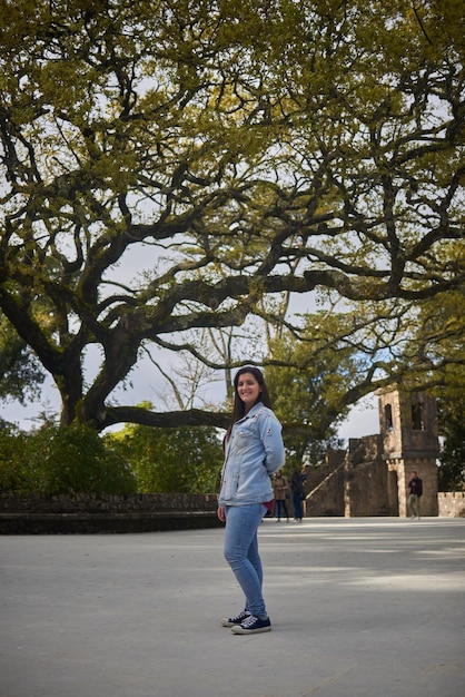 Foto retrato de uma mulher adulta de pé na rua contra uma árvore