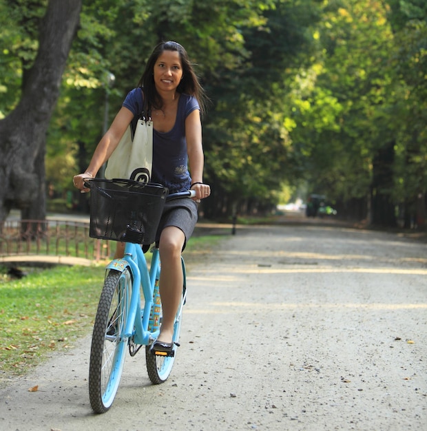 Foto retrato de uma mulher adulta sorridente andando de bicicleta na estrada