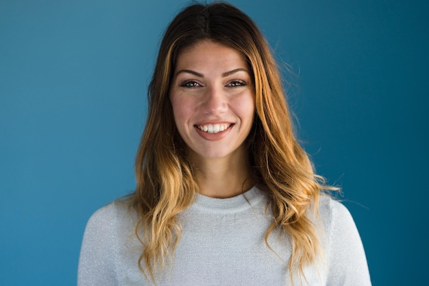 Foto retrato de uma mulher adulta sorridente contra um fundo azul