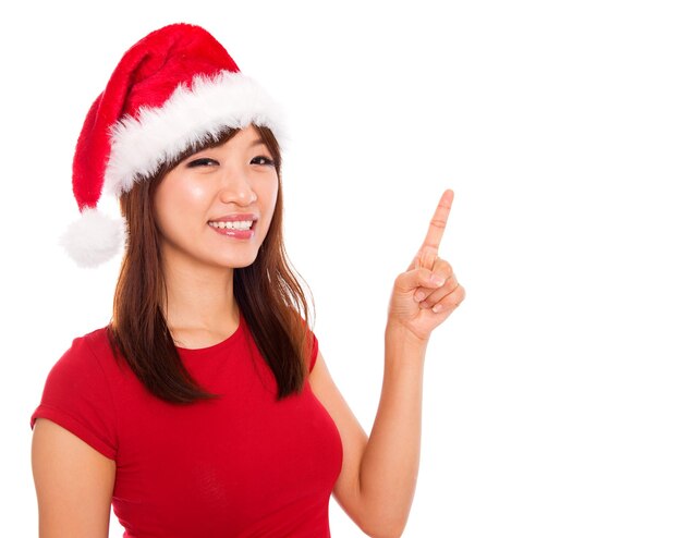 Foto retrato de uma mulher adulta sorridente usando um chapéu de papai noel enquanto está de pé contra um fundo branco