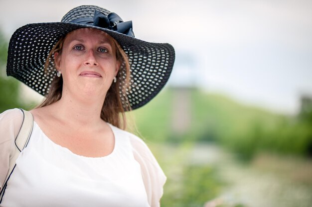 Retrato de uma mulher adulta usando um chapéu enquanto está de pé contra o céu