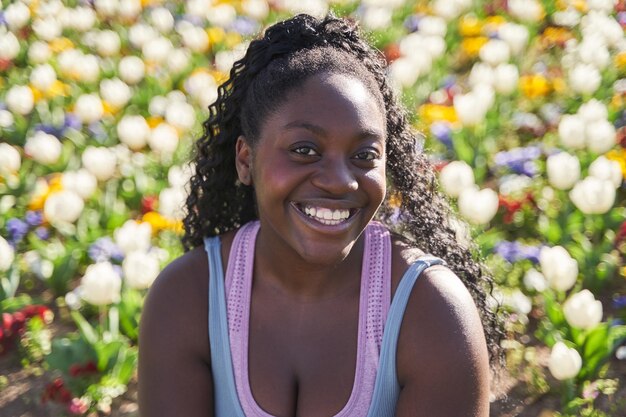 retrato de uma mulher afro-americana em um ambiente cheio de flores coloridas