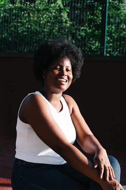 Retrato de uma mulher afro-americana feliz na rua no verão.