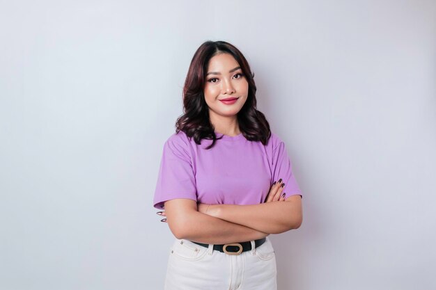 Retrato de uma mulher asiática sorridente confiante de pé com os braços cruzados e olhando para a câmera isolada sobre fundo branco