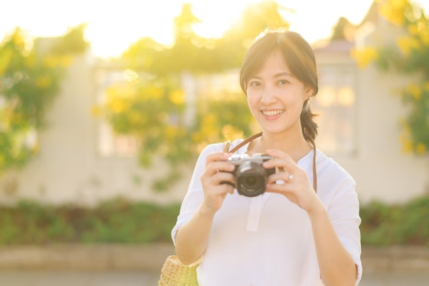 Retrato de uma mulher asiática viajante usando câmera na rua de Bangkok Tailândia Ásia conceito de férias de turismo de verão