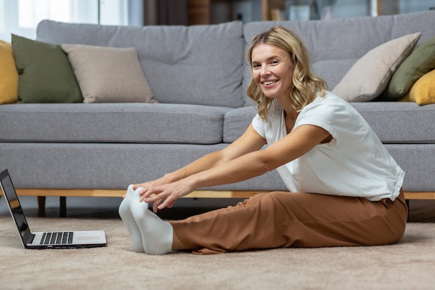 Retrato de uma mulher ativa em casa fazendo exercícios físicos e ioga, dona de casa madura olhando para