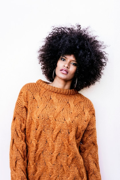 Foto retrato de uma mulher atraente afro em cima da parede. conceito de estilo de cabelo