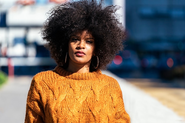Retrato de uma mulher atraente afro na rua. conceito de estilo de cabelo