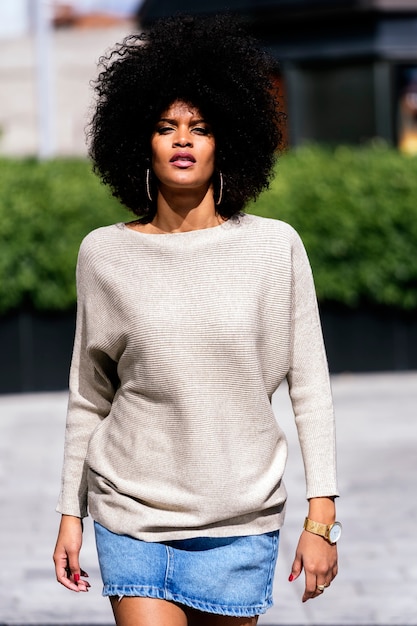 Retrato de uma mulher atraente afro na rua. Conceito de estilo de cabelo