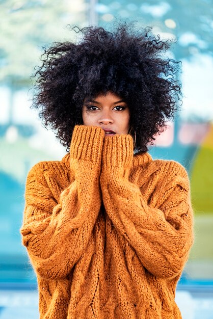 Retrato de uma mulher atraente afro na rua. Conceito de estilo de cabelo