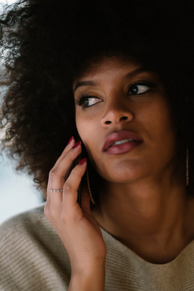 Foto retrato de uma mulher atraente afro usando telefone celular na rua. conceito de mulher de negócios
