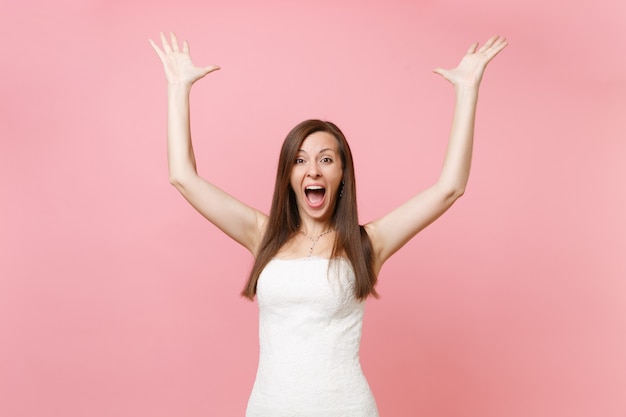 Retrato de uma mulher atraente feliz radiante num vestido de renda branca em pé estendendo as mãos