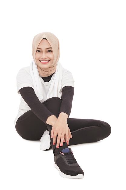 Retrato de uma mulher atraente muçulmana e esportiva sentada no chão