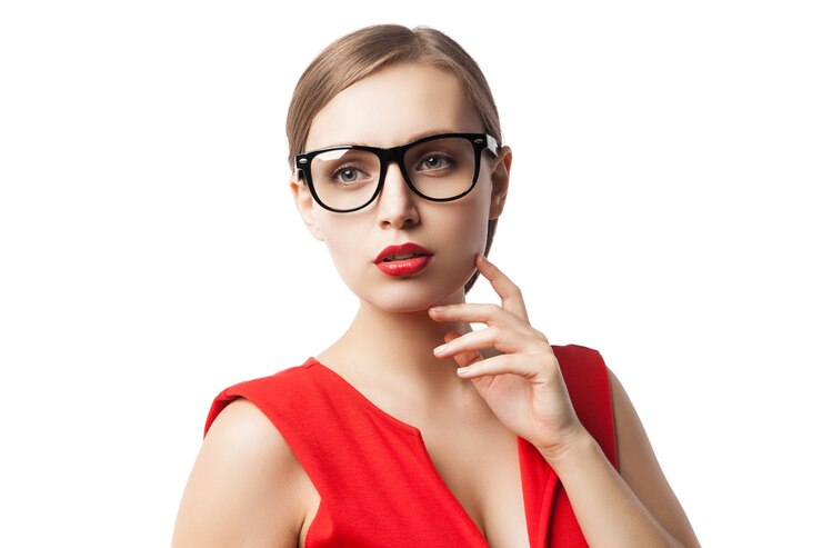 Foto retrato de uma mulher bem-sucedida e confiante de óculos e vestido vermelho com batom vermelho olhando para longe
