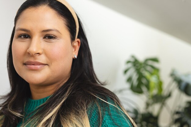 Foto retrato de uma mulher biracial feliz com cabelos longos e retos de pé em uma casa ensolarada