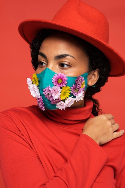 Retrato de uma mulher bonita com máscara e flores