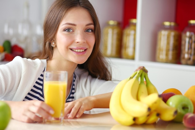 Retrato de uma mulher bonita segurando um copo com um suco saboroso